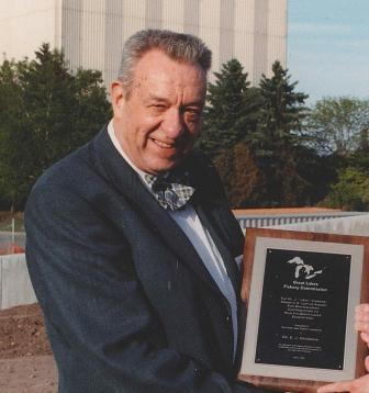 Edwin J. Crossman holding an Award