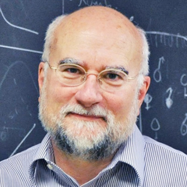 An older mna, mostly bald, with white hair and a short white beard, wearing glasses and a casual button-down shirt